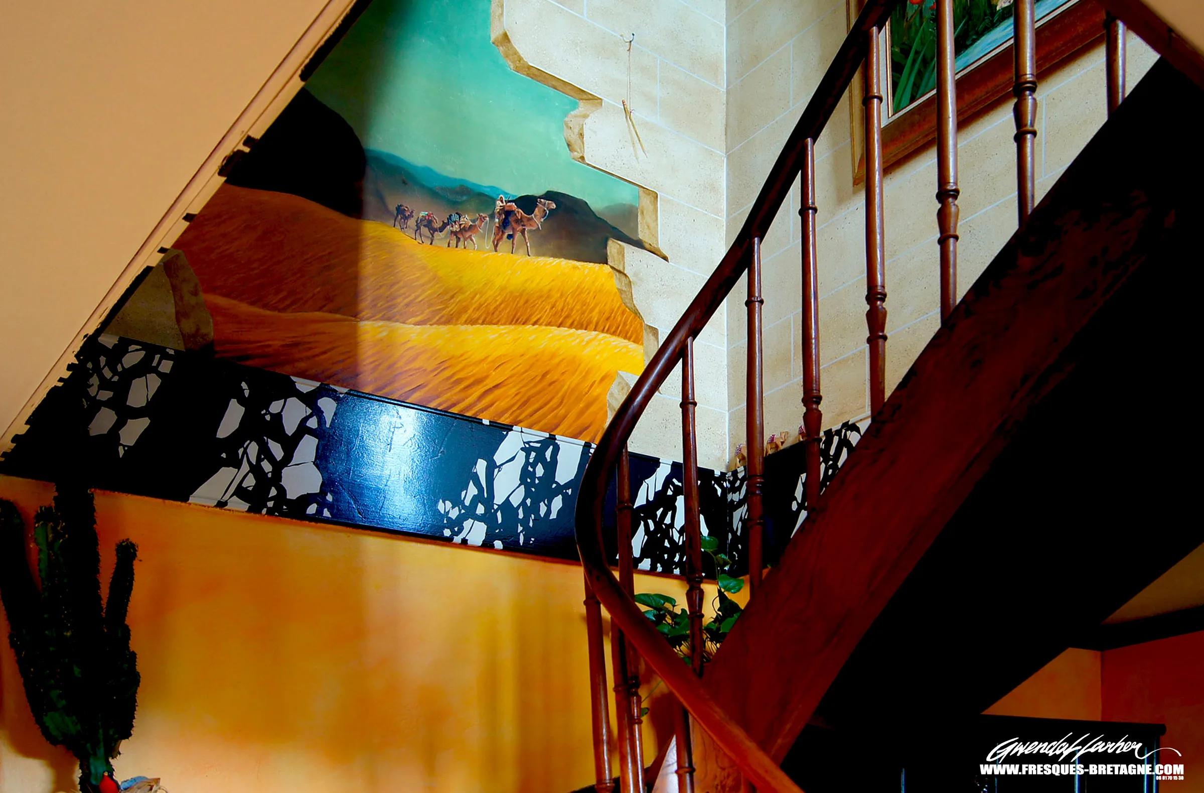 Trompe-l'œil de désert avec caravane de dromadaires ouvrant un mur de cage d'escalier, décor exotique d'intérieur à Morlaix